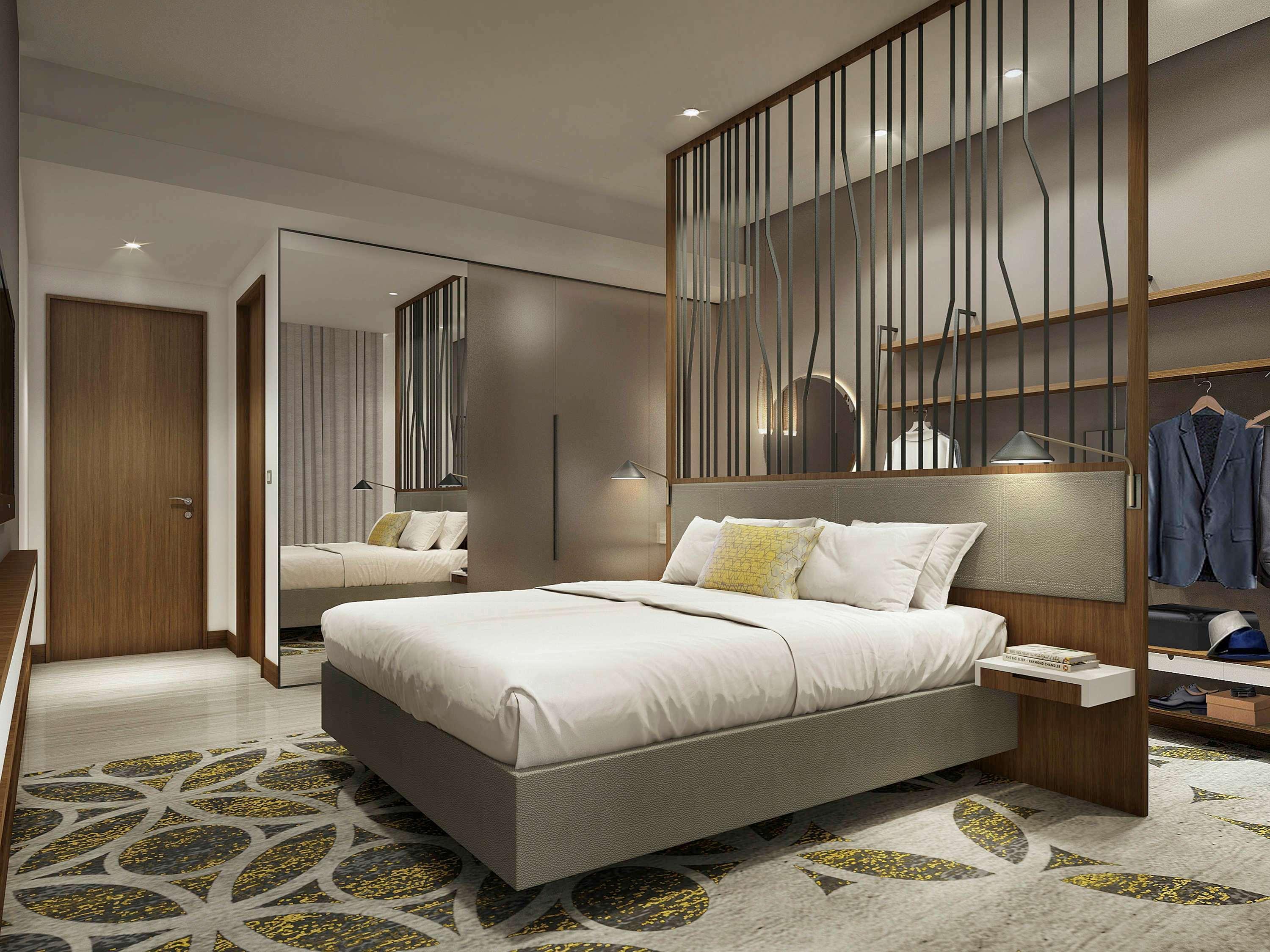 Grand Mercure Dubai City Exterior foto The photo shows a modern hotel room featuring a neatly made bed with white linens and a decorative pillow. The room has a stylish wooden partition that separates the sleeping area from the rest of the space. There are bedside tables on either side of